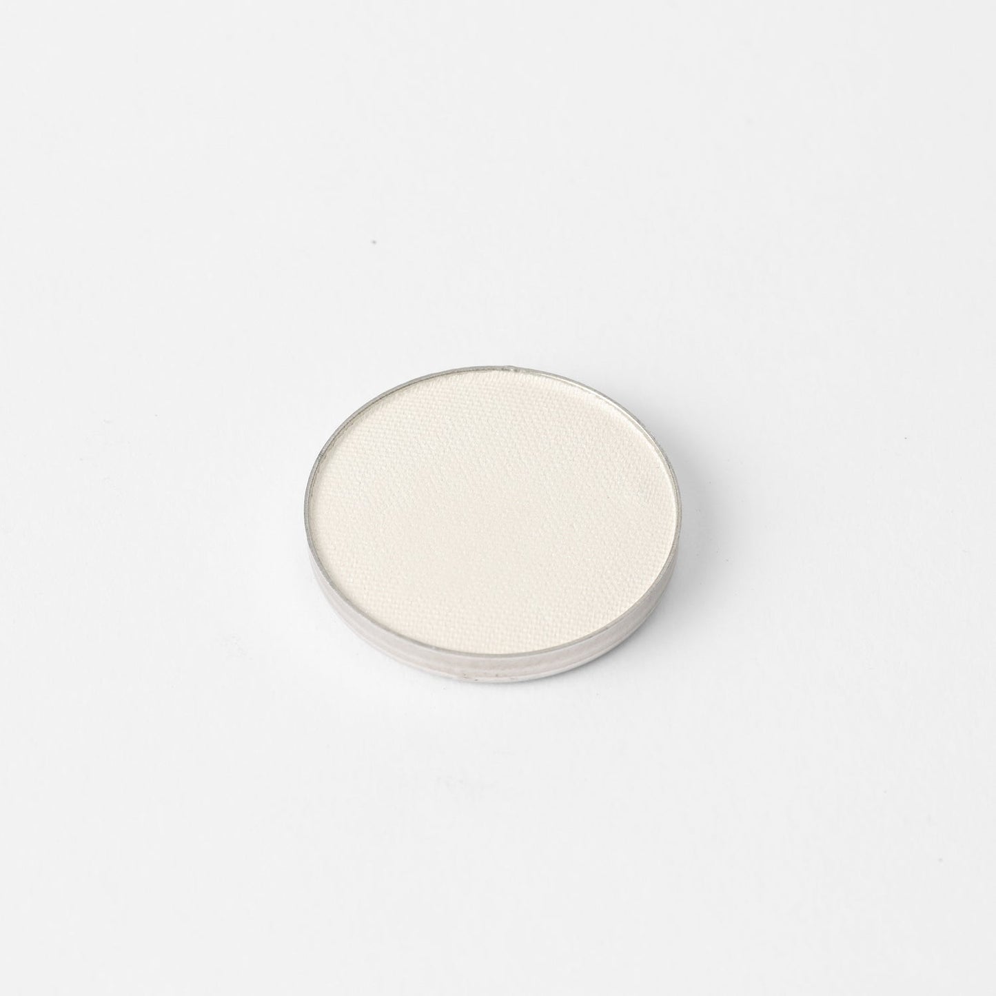 Round pressed eyeshadow pan with light shimmering neutral shade