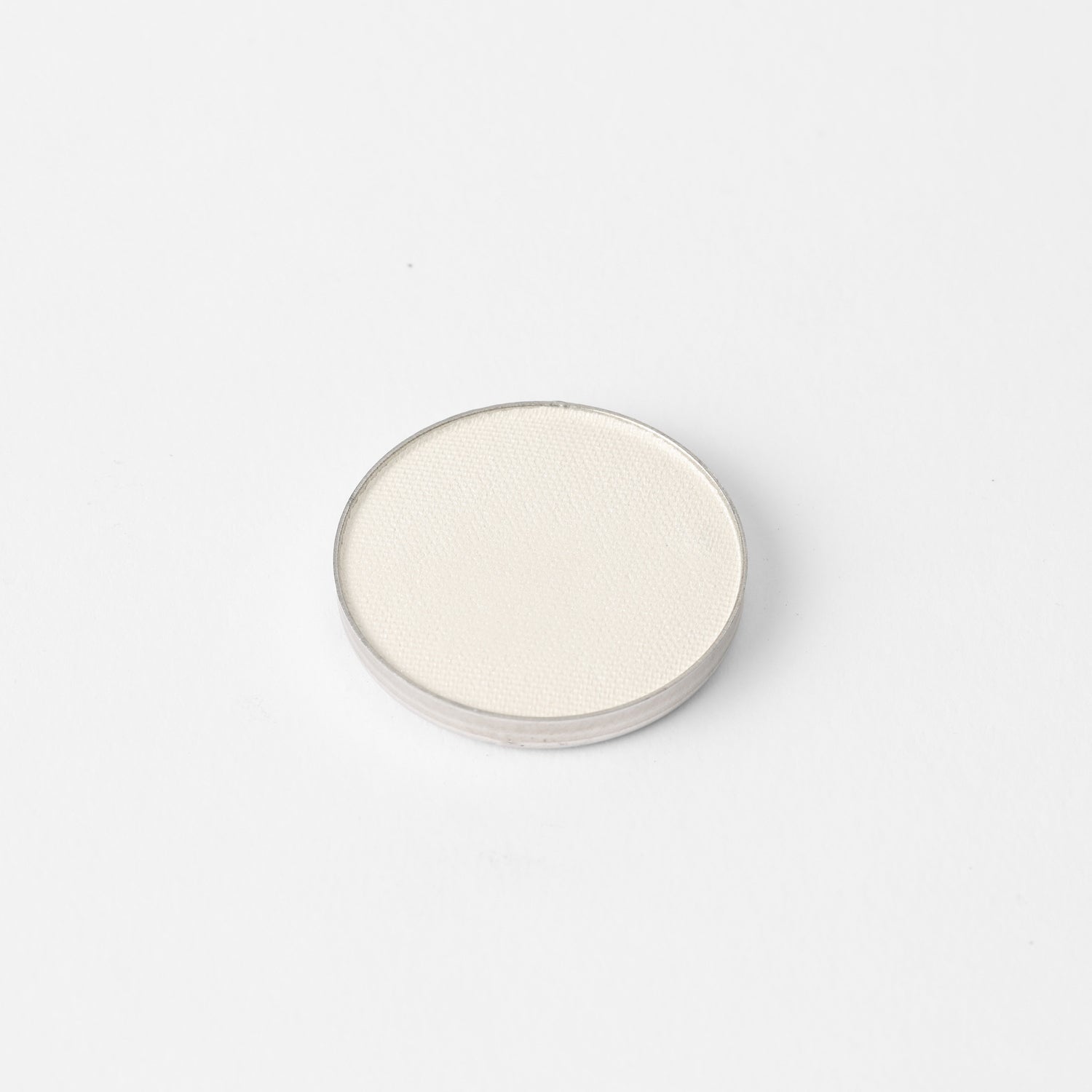 Round pressed eyeshadow pan with light shimmering neutral shade