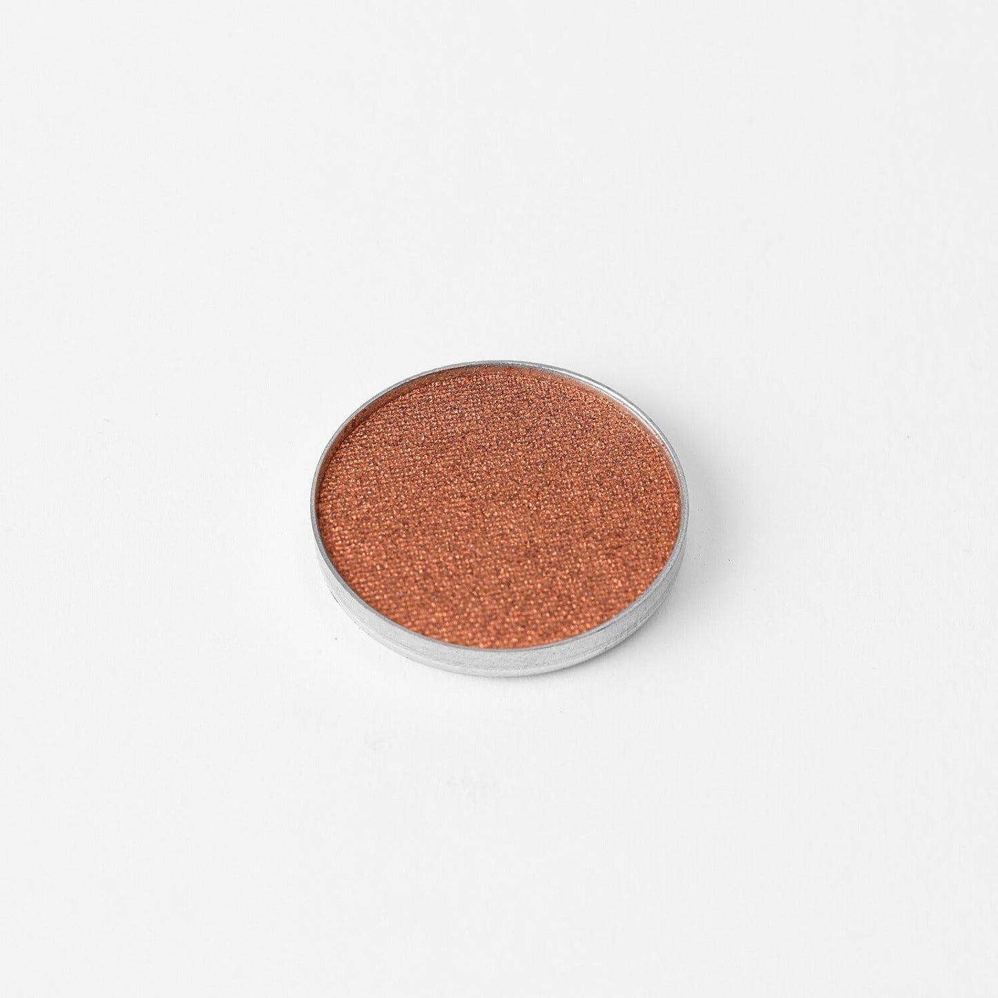 Pressed eyeshadow pan with copper rose-brown shimmer in a round compact