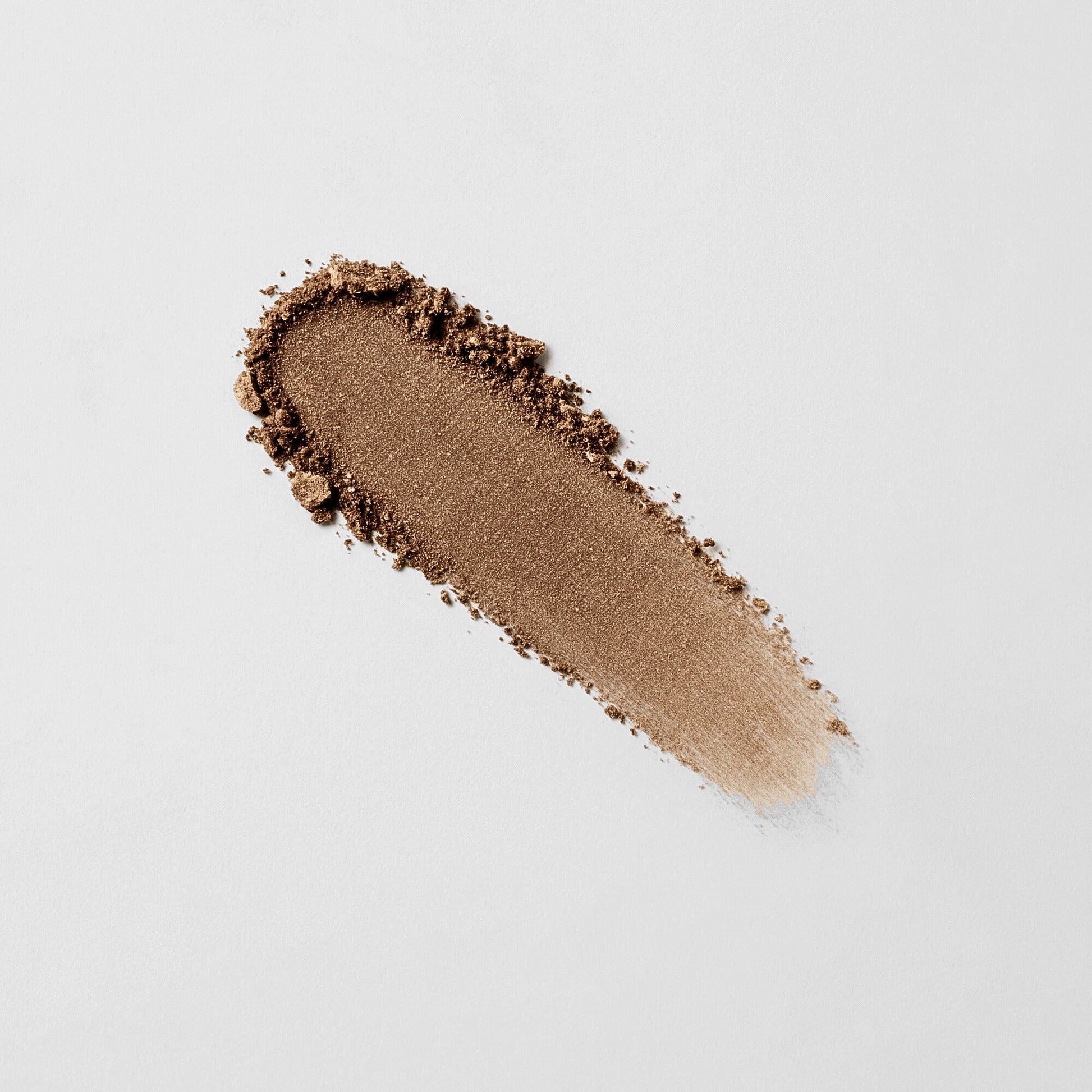 Pressed eyeshadow swatch in warm bronze brown with visible powder texture.