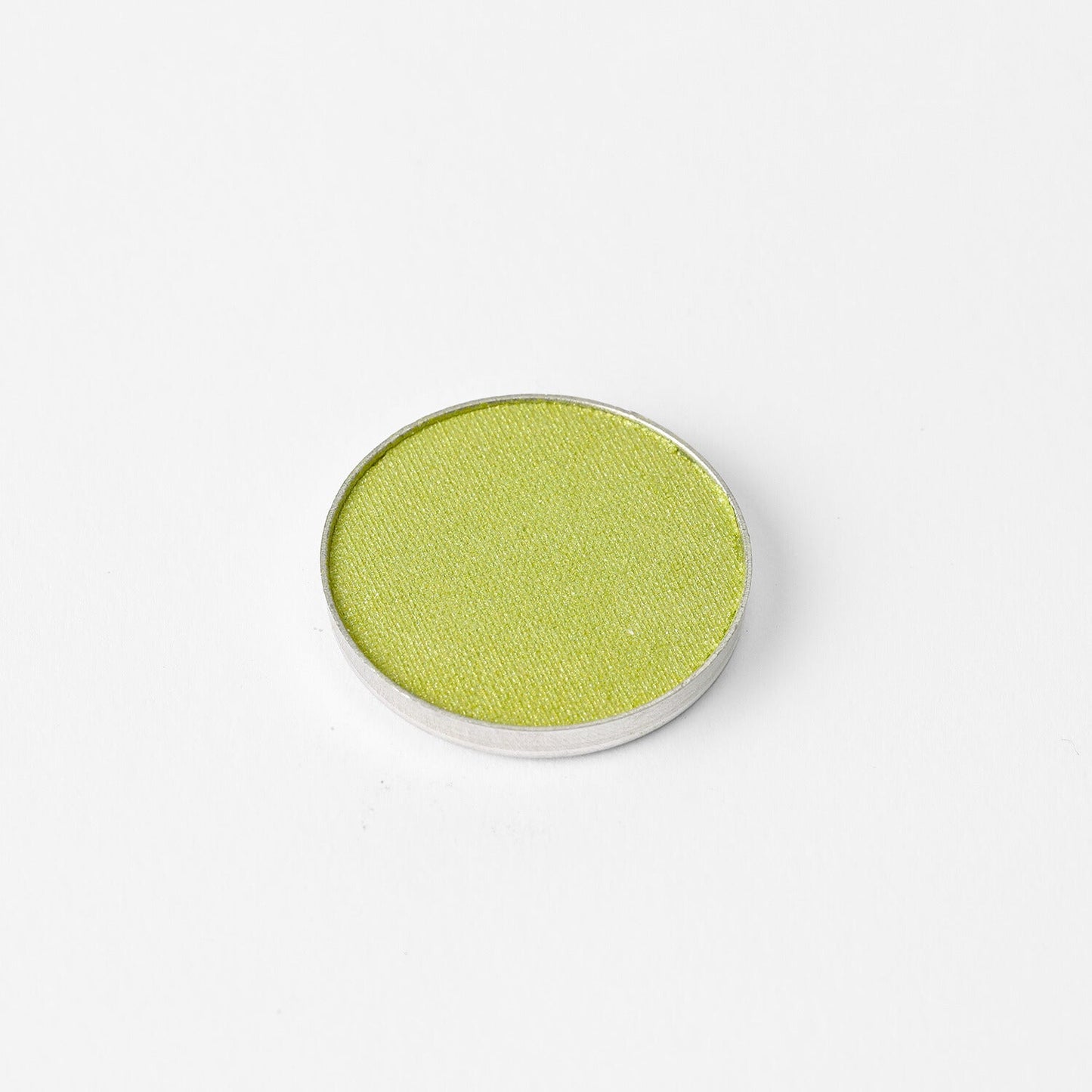 Pressed eyeshadow pan with bright olive green shade in a round compact.