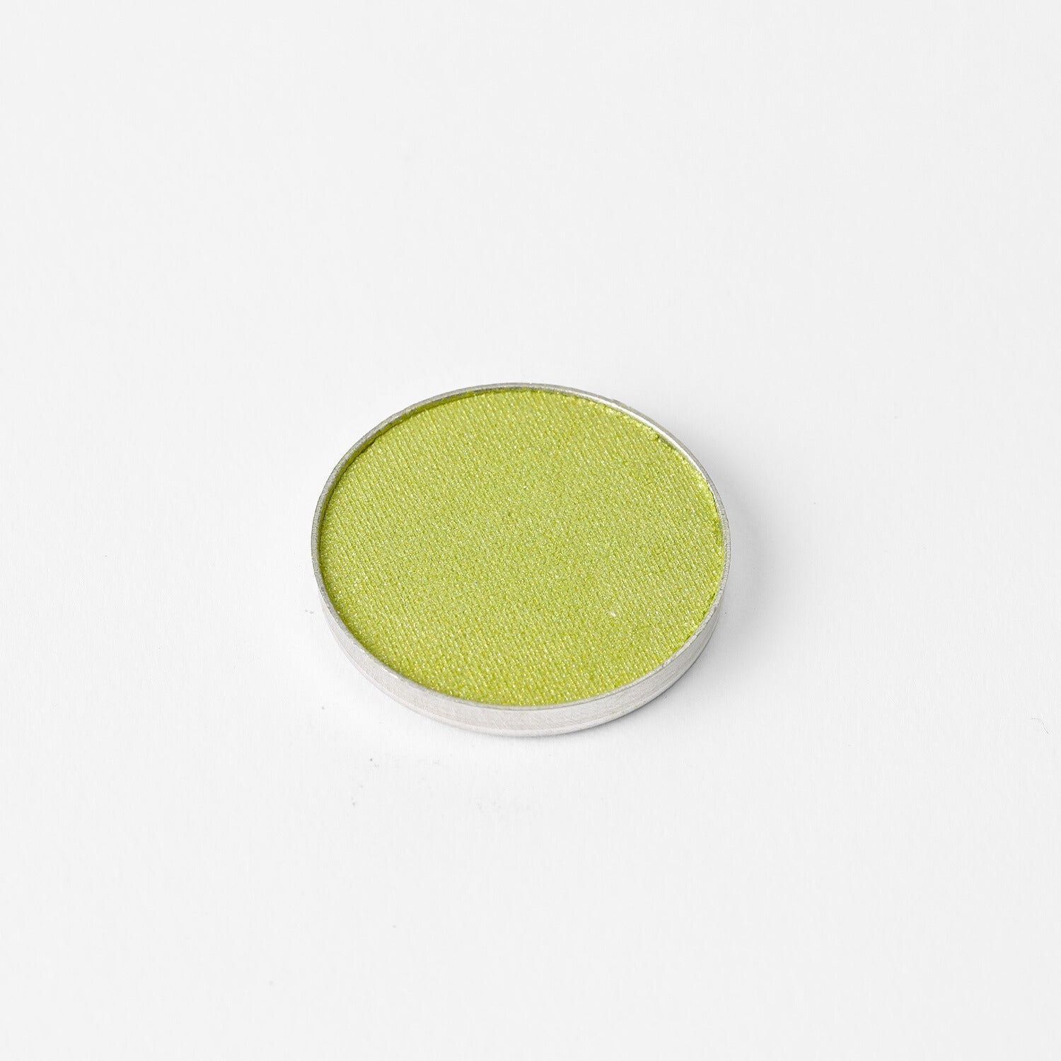 Pressed eyeshadow pan with bright olive green shade in a round compact.
