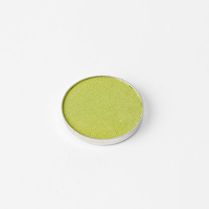 Pressed eyeshadow pan with bright olive green shade in a round compact.