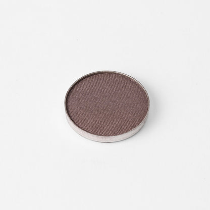 Pressed eyeshadow pan with a taupe-brown shimmer finish in a round case
