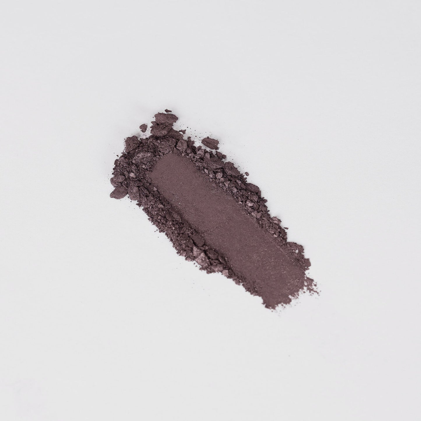 Pressed eyeshadow swatch in dark brown shimmer with a textured powder trail