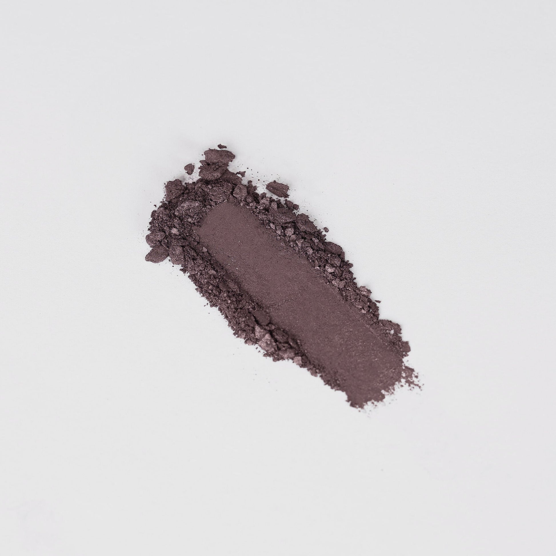 Pressed eyeshadow swatch in dark brown shimmer with a textured powder trail
