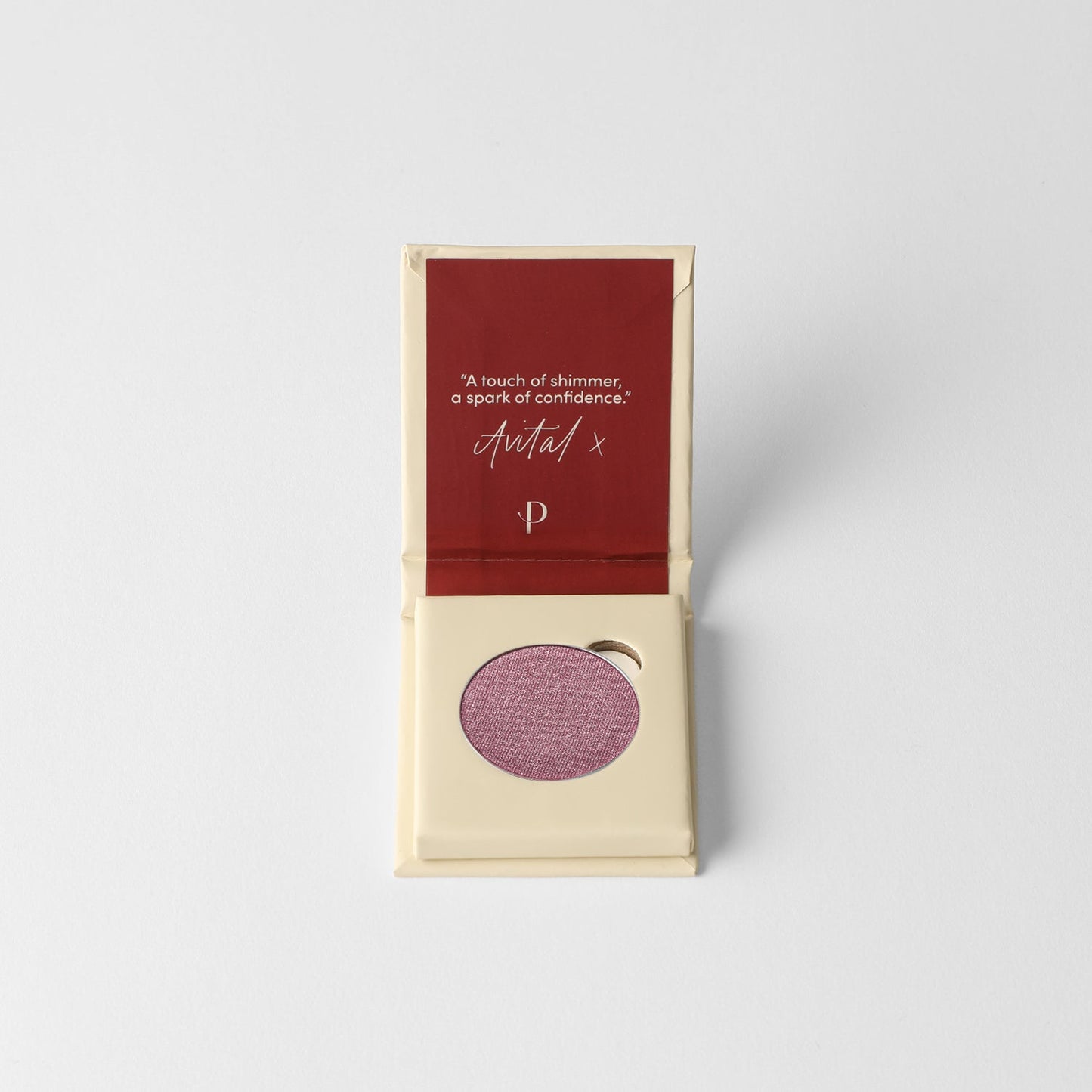 Pressed eyeshadow pan with mauve-purple shimmer, in open case