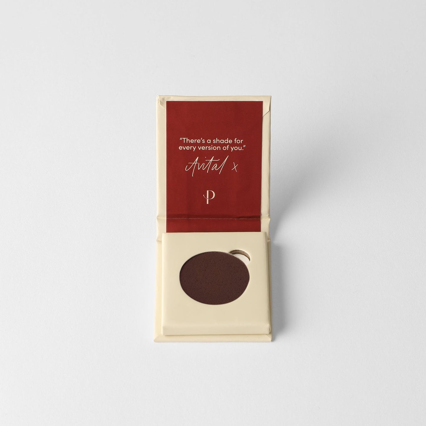 Pressed eyeshadow pan, dark brown in a small cardboard box