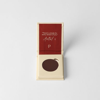 Pressed eyeshadow pan, dark brown in a small cardboard box