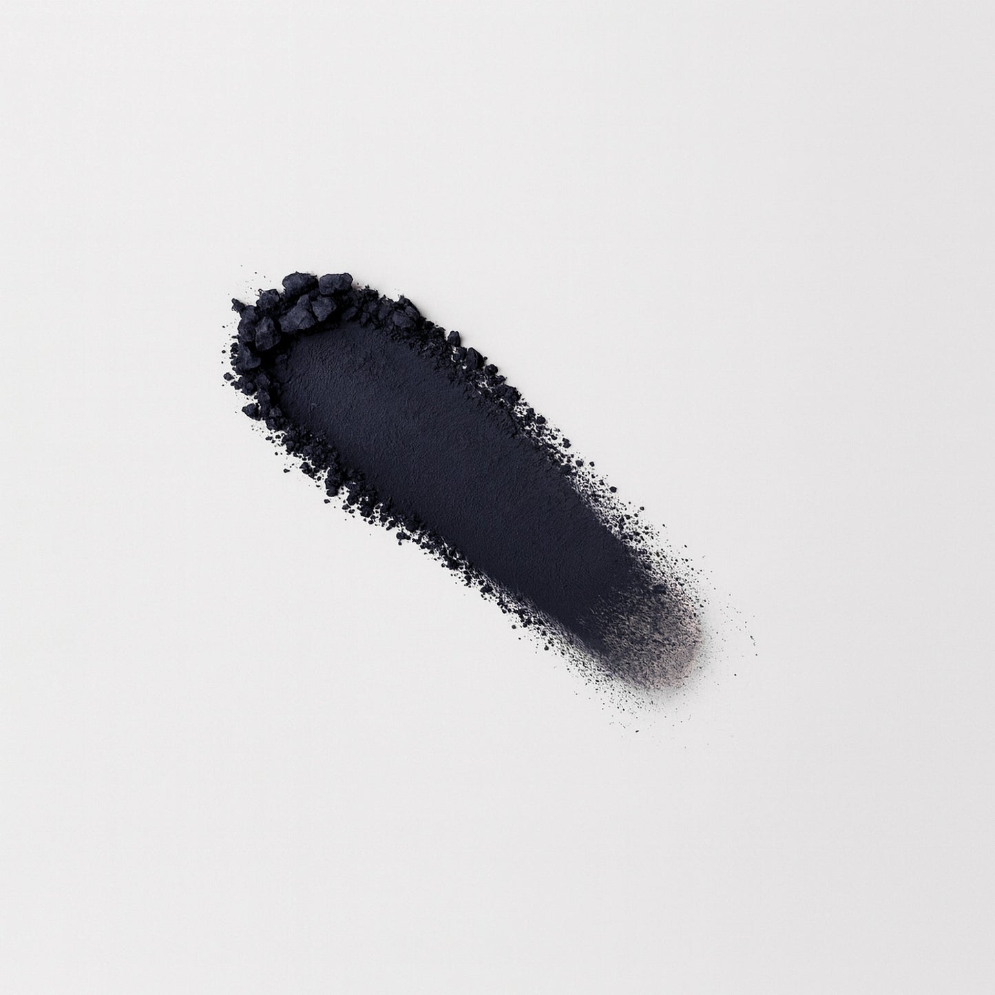 Matte pressed eyeshadow swatch, dark navy/black matte powder on surface.