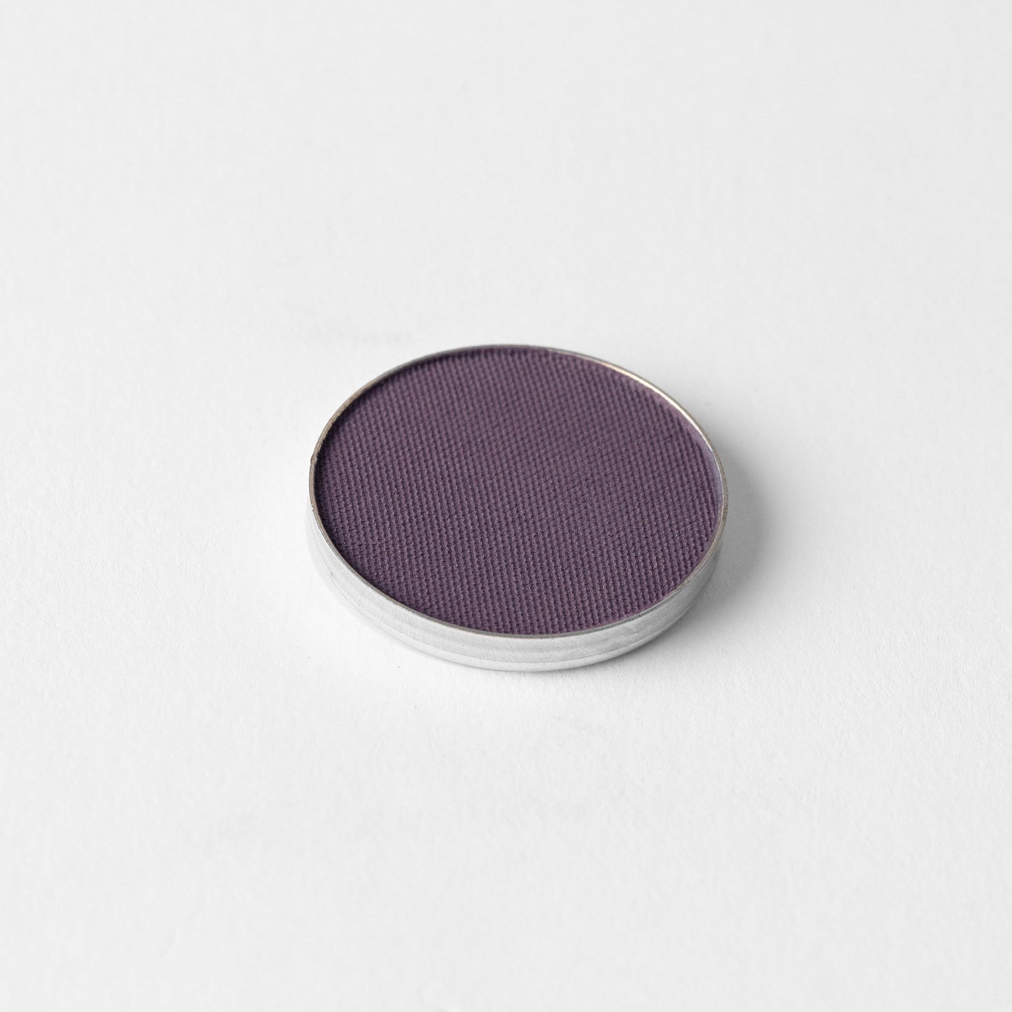 Pressed eyeshadow pan, plum purple matte powder.