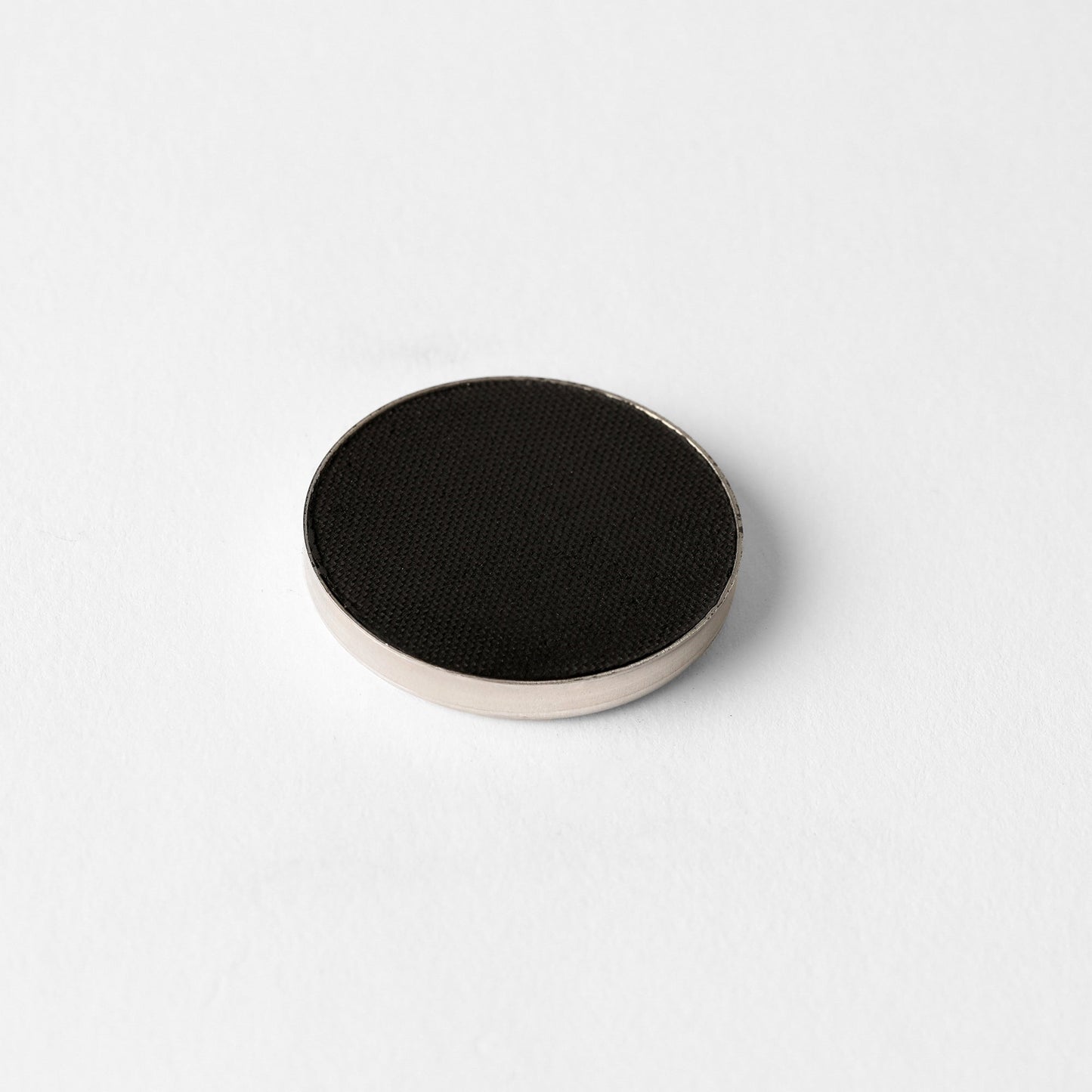 Pressed eyeshadow pan, black matte powder.