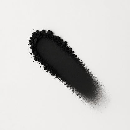 Matte pressed eyeshadow swatch, black matte powder on surface.