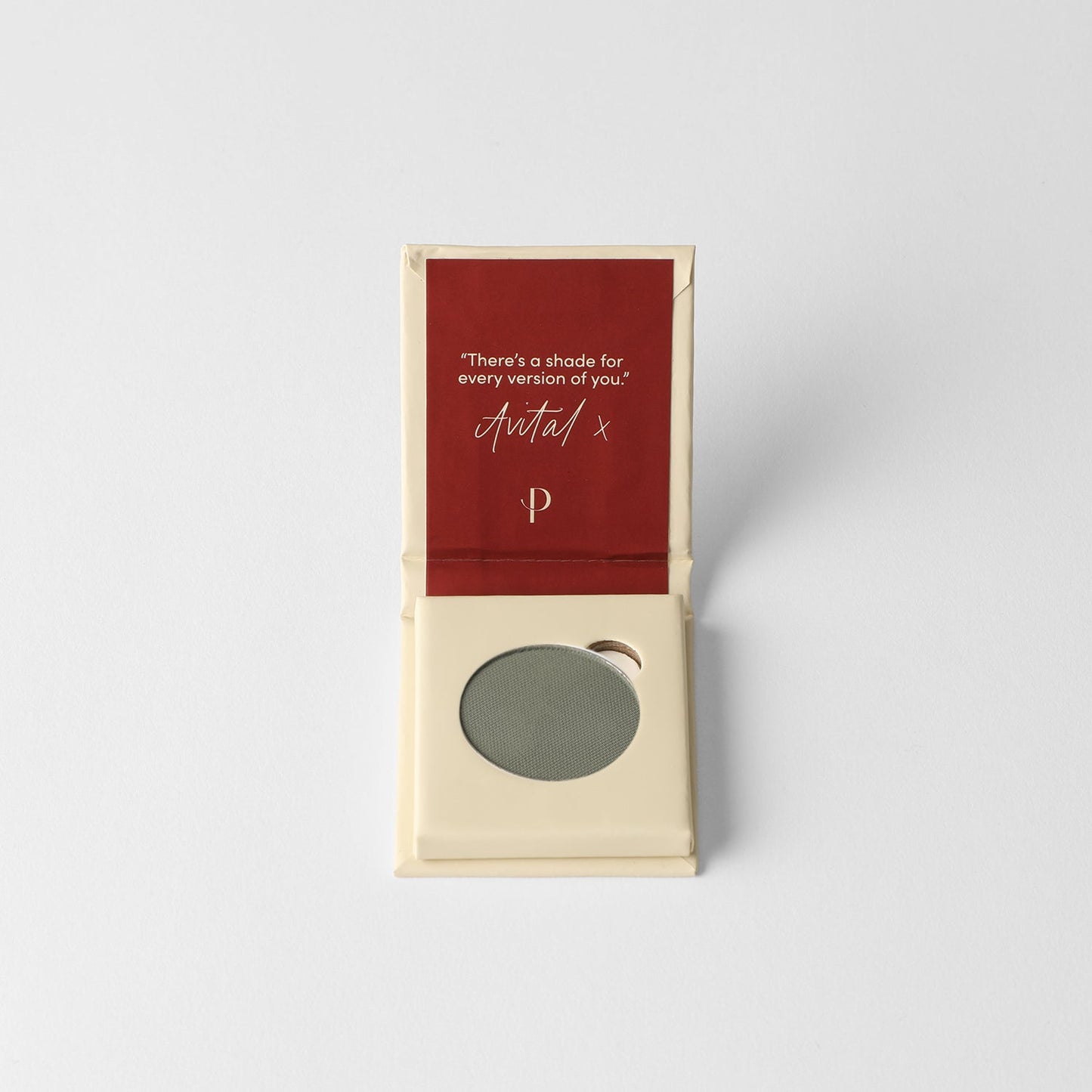 Pressed eyeshadow pan, muted green round compact in a cardboard box