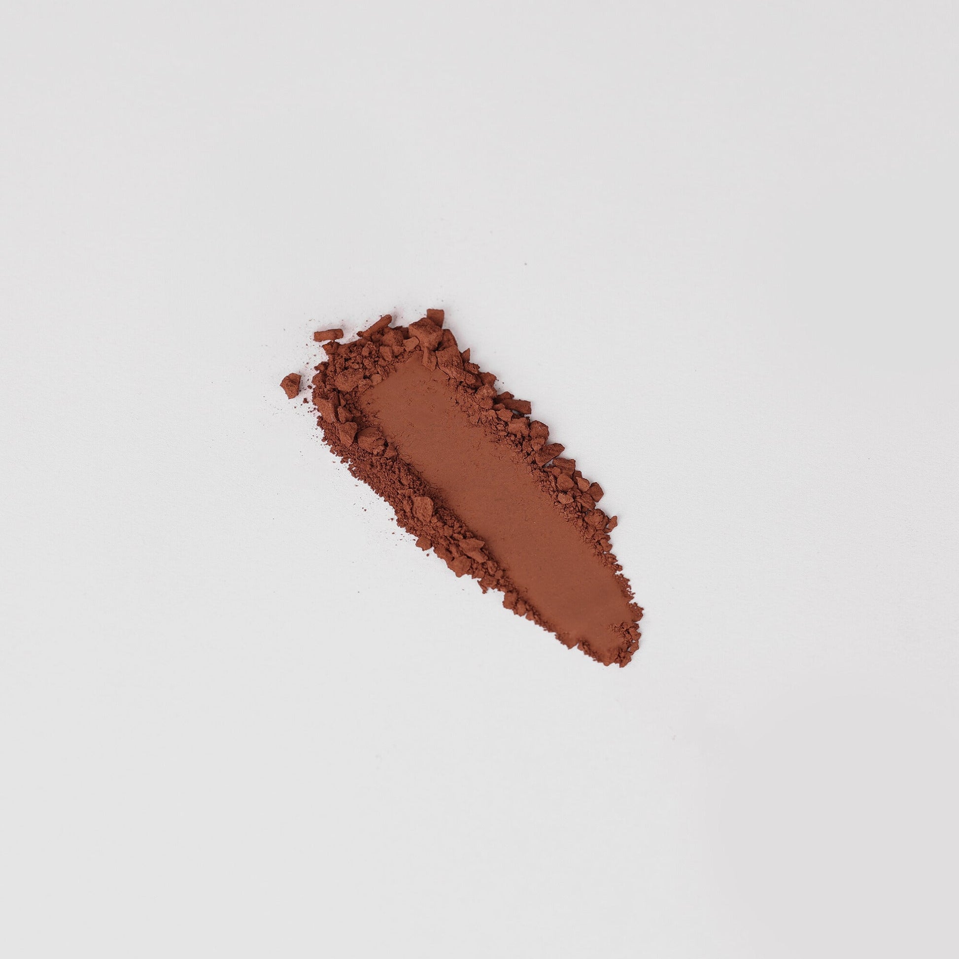Matte pressed eyeshadow swatch, warm reddish-brown