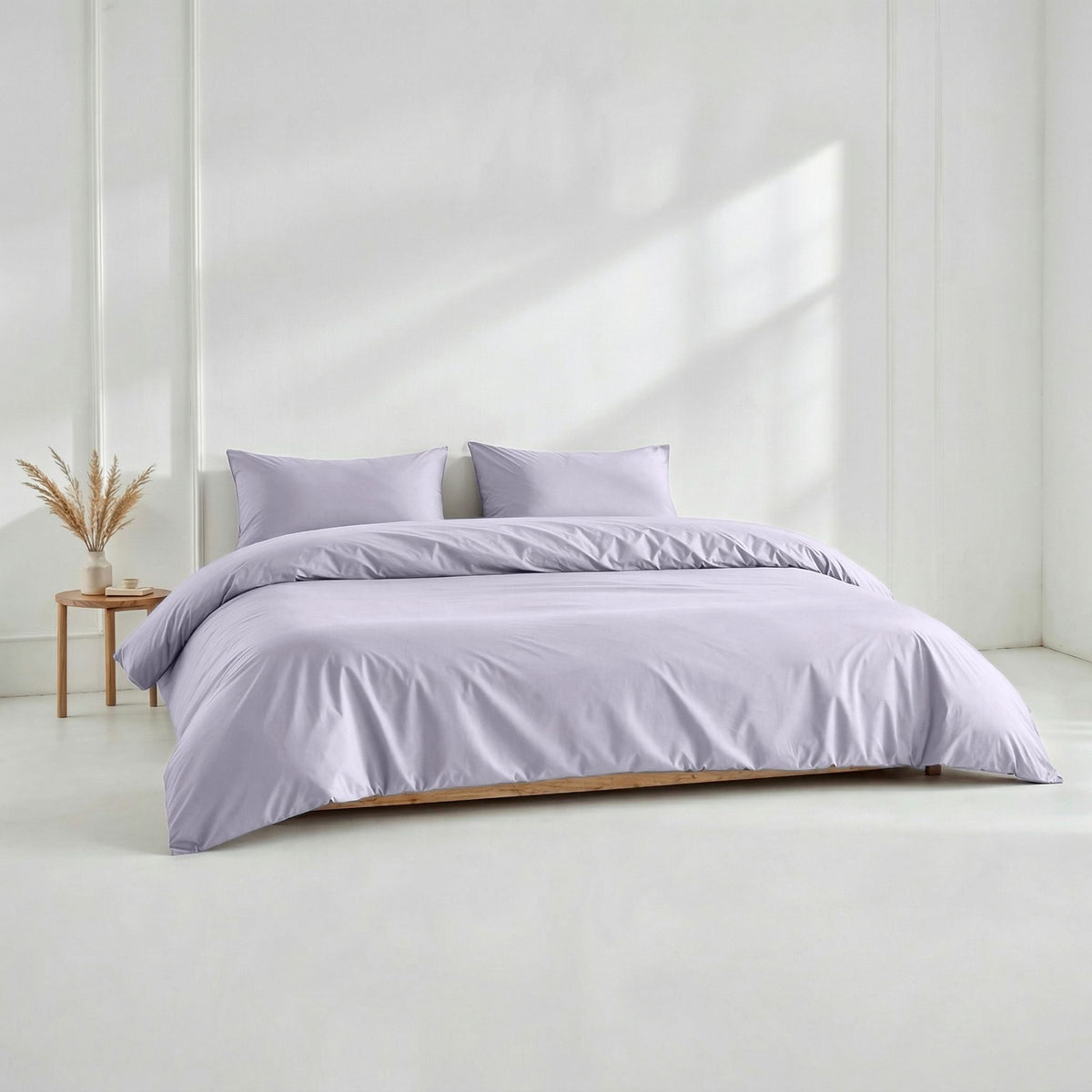 Lilac sateen pillowcase set with two matching pillows on a bed