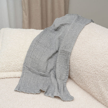 Gray towel draped over a cream couch cushion