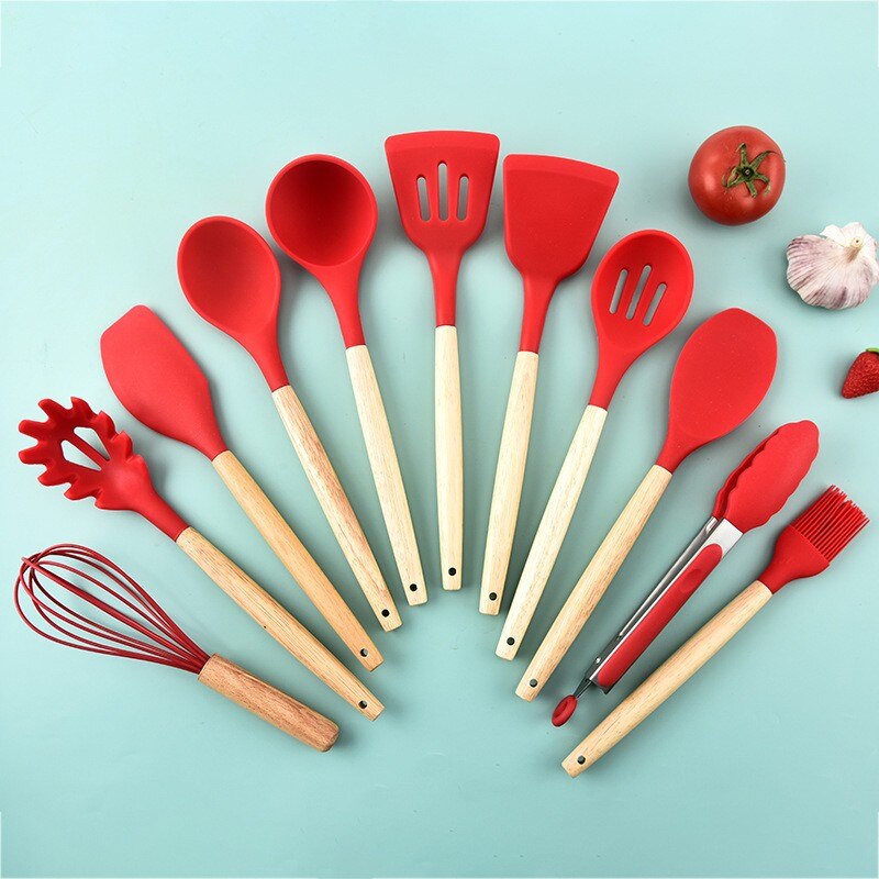 Red silicone cooking utensils with wooden handles, including spatula, spoon, and fork tools