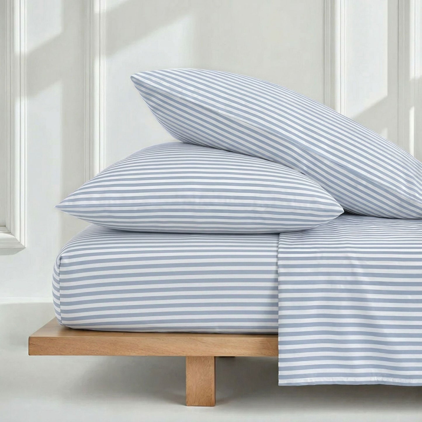 Blue and white striped sateen duvet cover with two matching pillows on bed