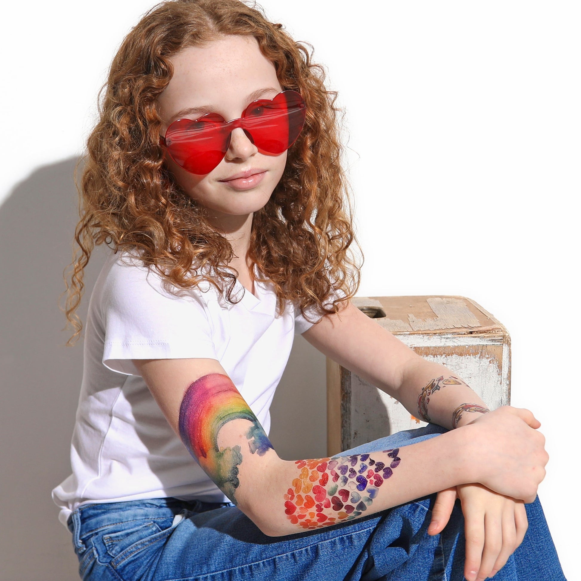Temporary tattoo sleeve with rainbow and heart-pattern design on a kid’s arm