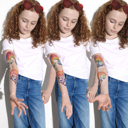 Temporary tattoo sleeve designs on kid’s arms: rainbow, hearts, and clouds