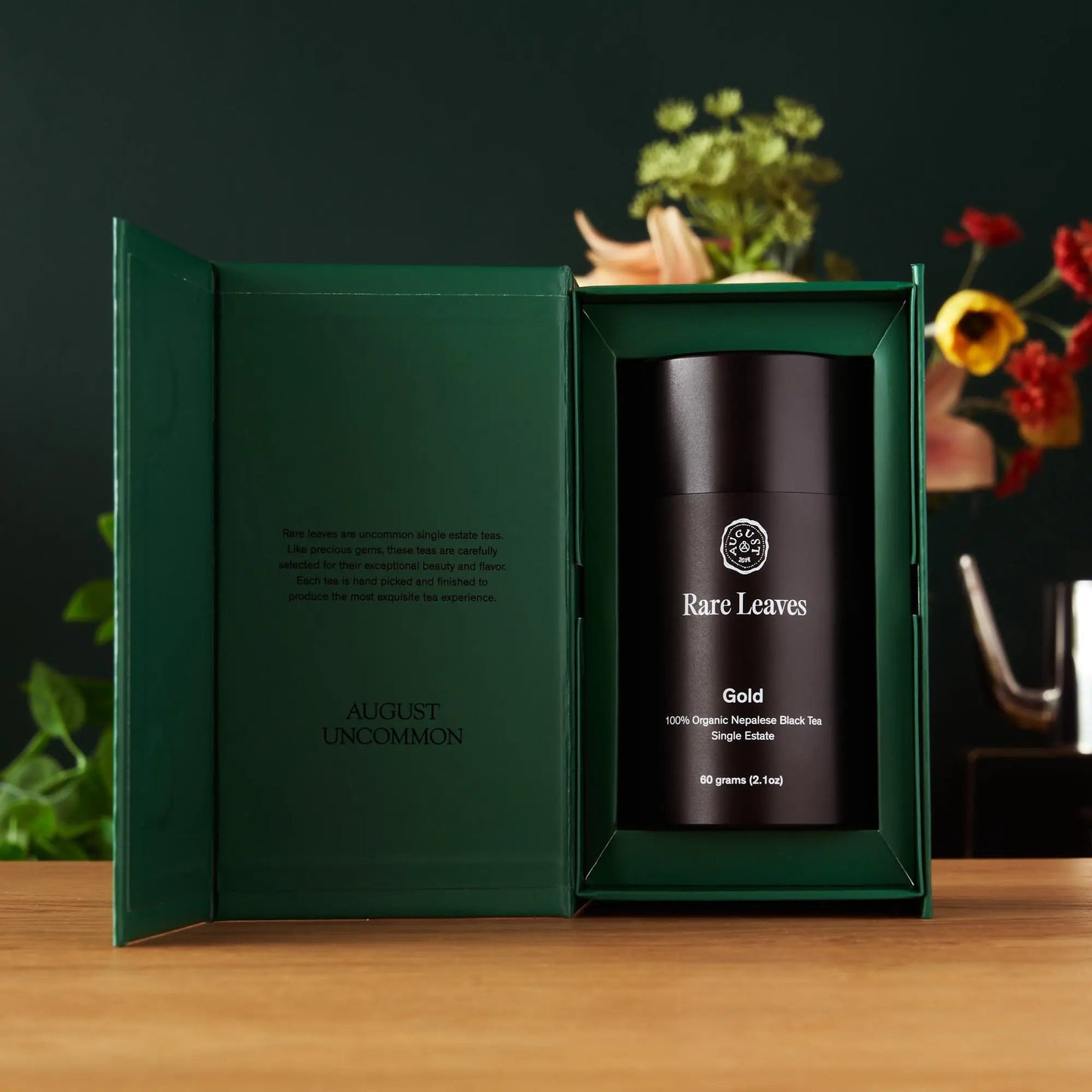 Gold black tea gift box, open green carton with black canister inside