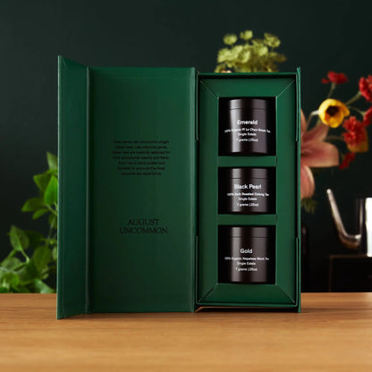 Tea sampler with open green box showing mini tins: Emerald, Black Pearl, Gold.