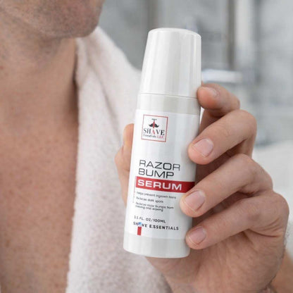 Razor Bump Serum bottle held in hand, white pump with red-accent label