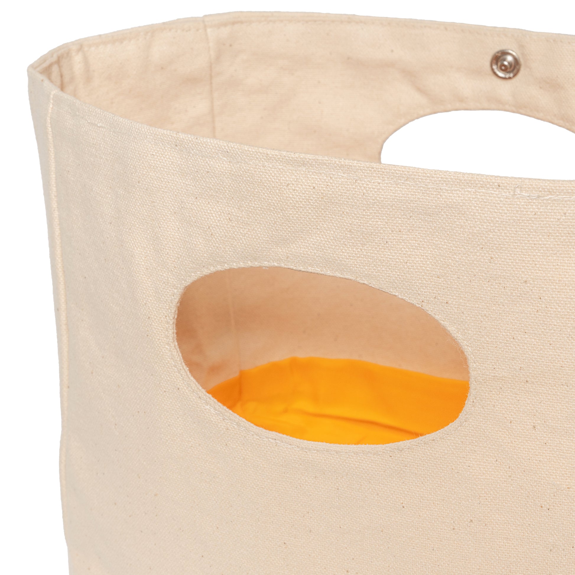 Light-beige canvas basket with large oval side cutout showing orange lining