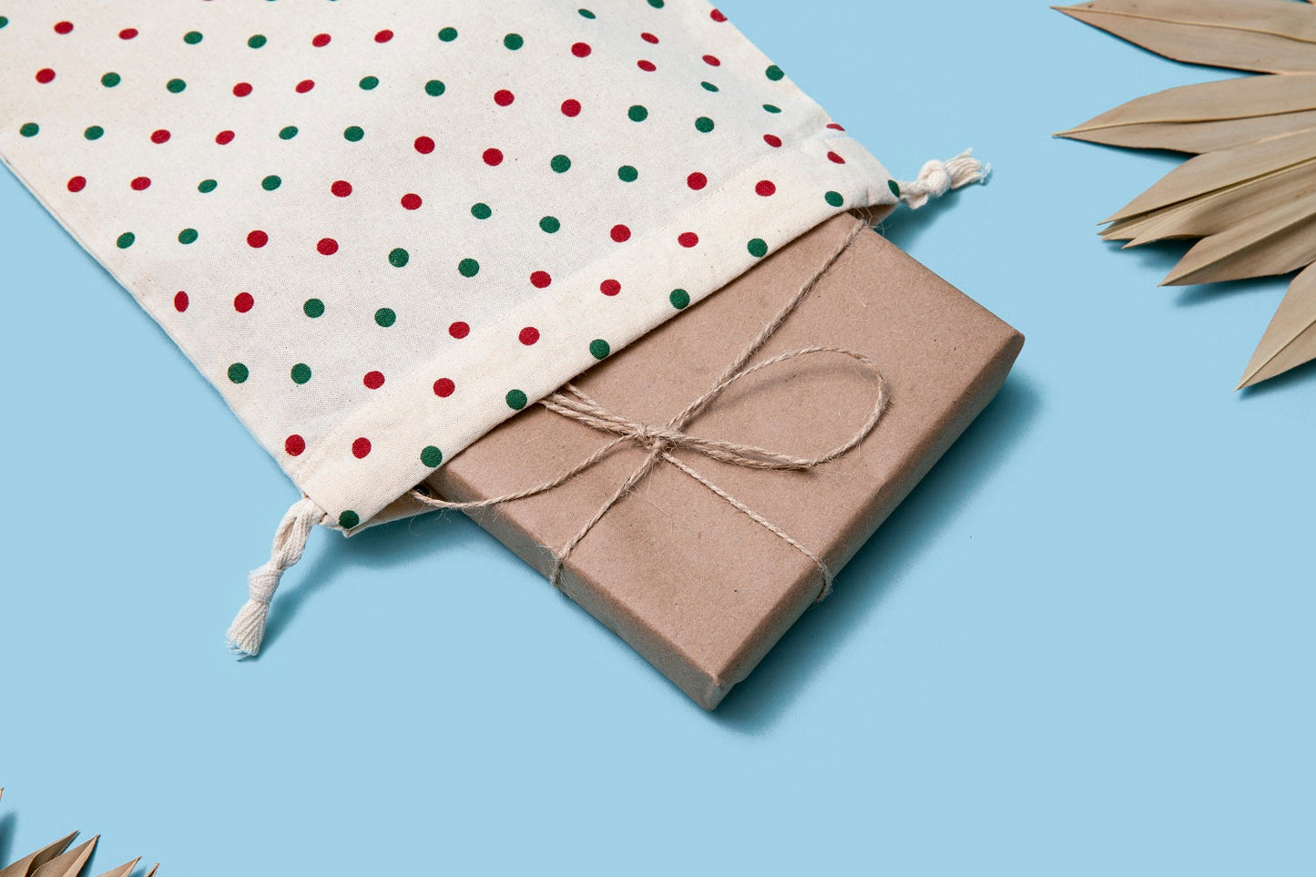 White cloth drawstring gift bag with red polka dots, tied gathered top