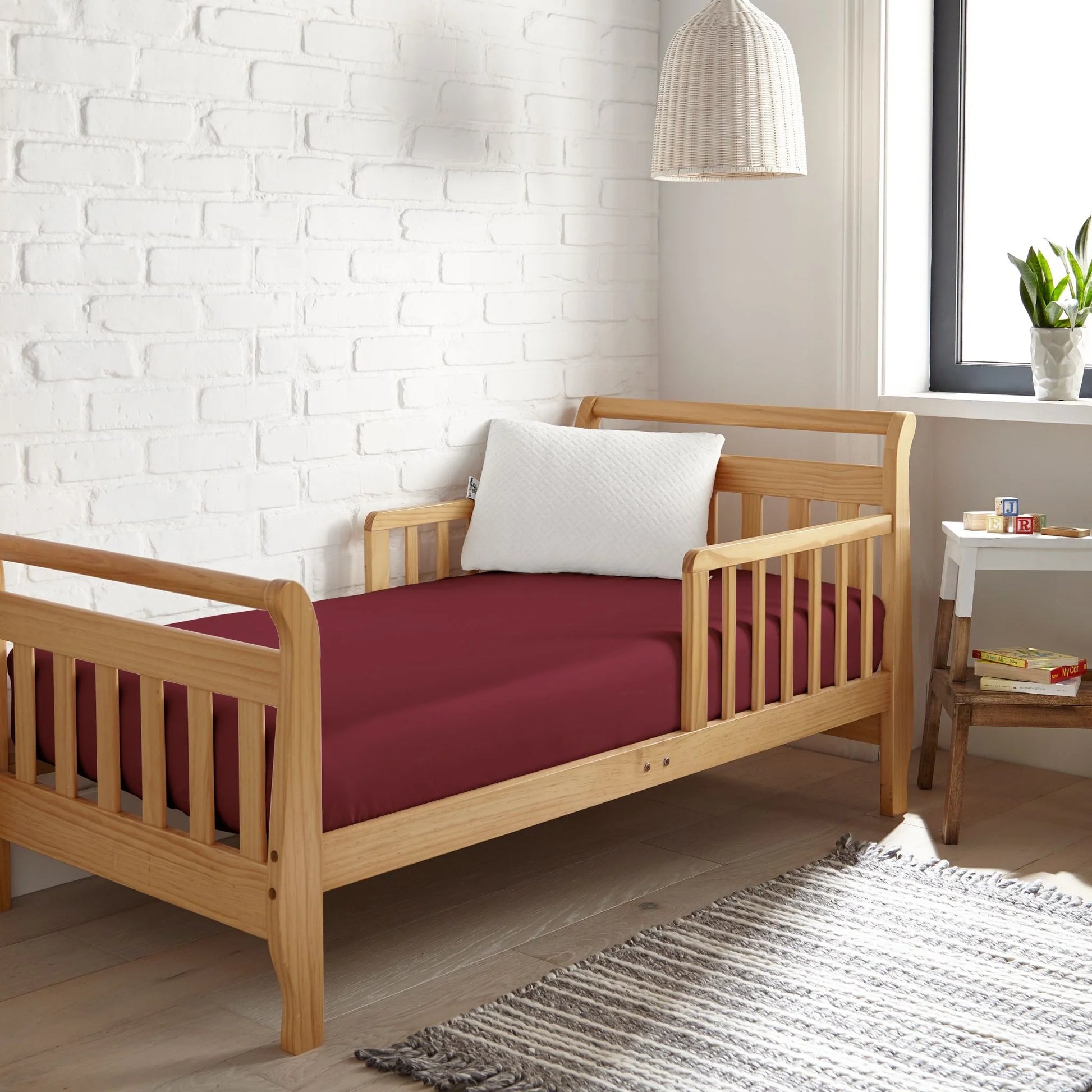 Crib fitted sheet in burgundy, smooth fitted fabric covering crib mattress