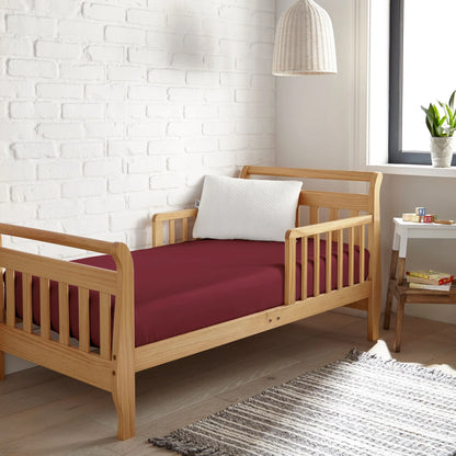 Crib fitted sheet in burgundy, smooth fitted fabric covering crib mattress
