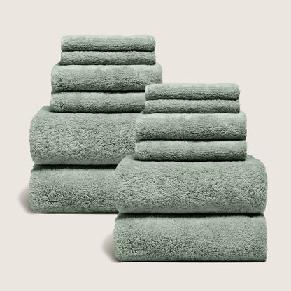 Set of dark green plush towels stacked and folded, soft terry loops