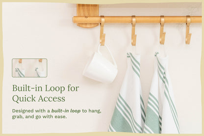 White kitchen towels with green stripes hanging from a wooden rod
