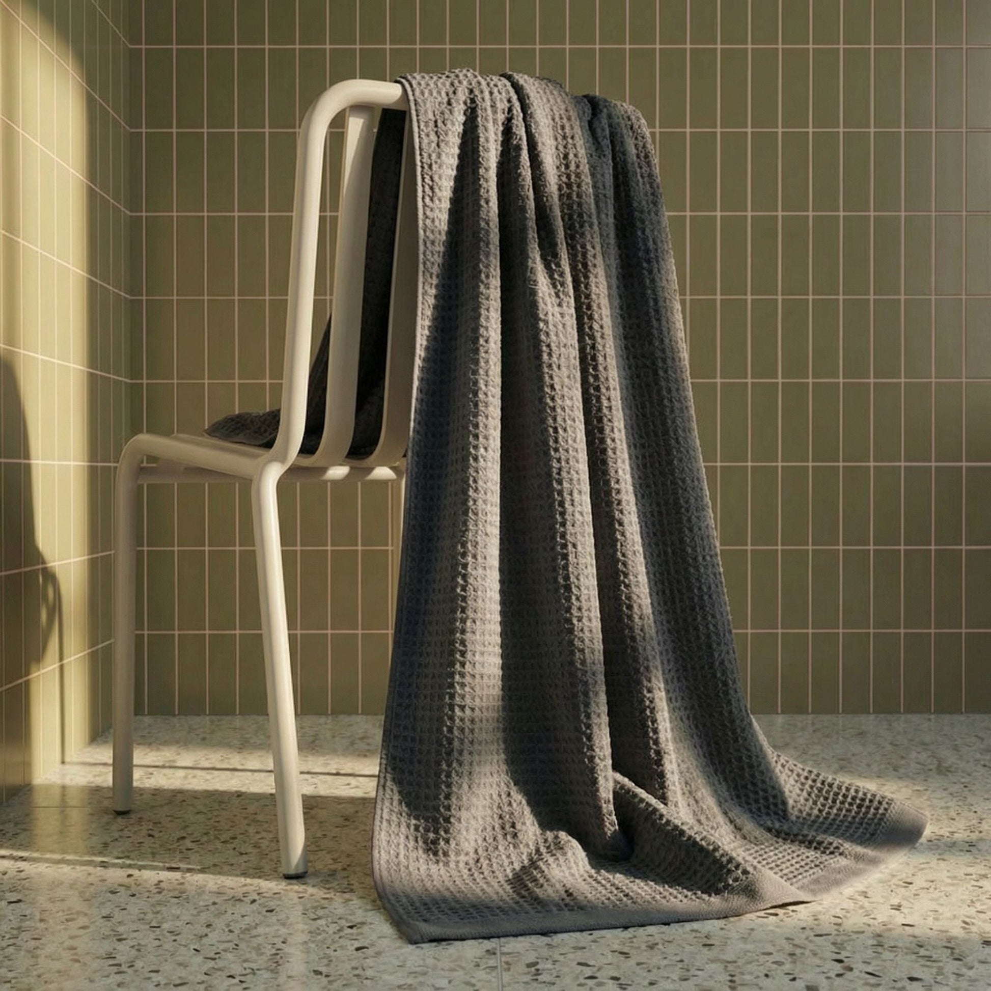 Charcoal waffle weave towels hanging over a rack, textured grid weave visible
