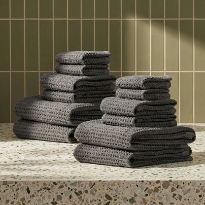 Charcoal waffle weave towels stacked in neat piles, textured grid weave