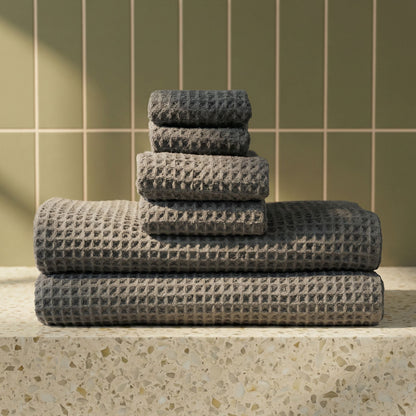 Charcoal waffle weave towels stacked with visible waffle texture and folded edges