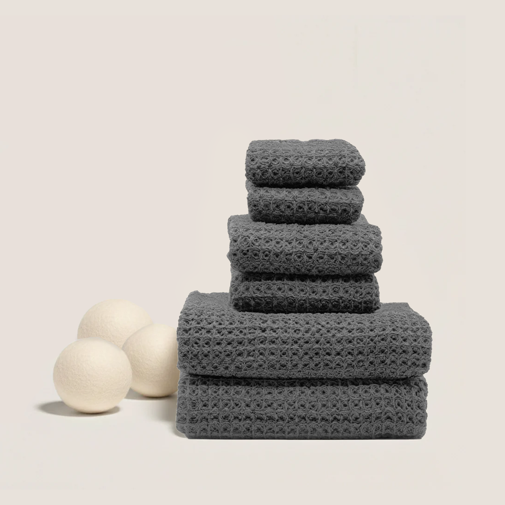 Charcoal waffle cotton towel stack with three towels on top, textured weave