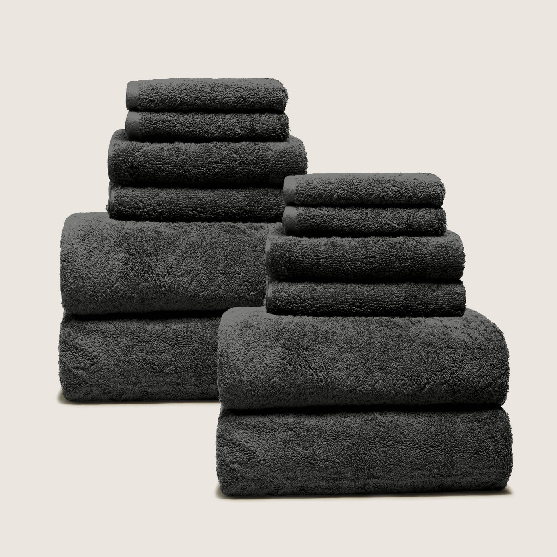 Assorted folded plush towels, dark gray charcoal, thick terry loop pile.