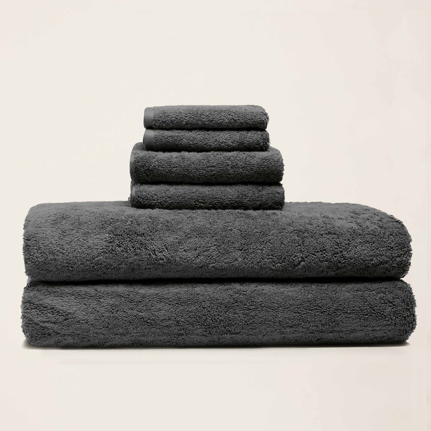 Gray cotton towels folded in a stack, thick plush terry finish