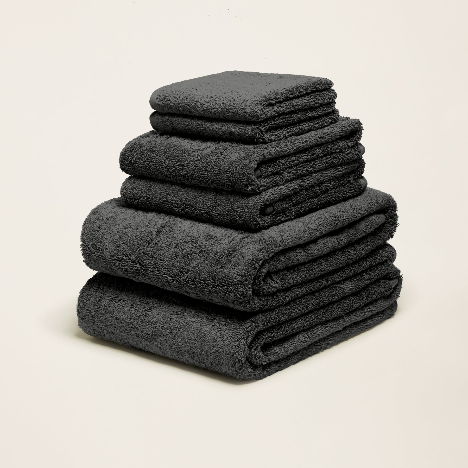 Charcoal gray cotton towels folded in a stack with plush terry texture