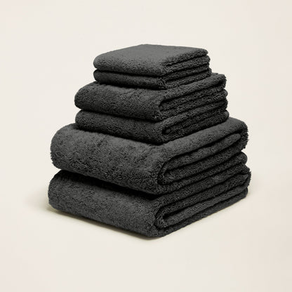 Charcoal gray cotton towels folded in a stack with plush terry texture