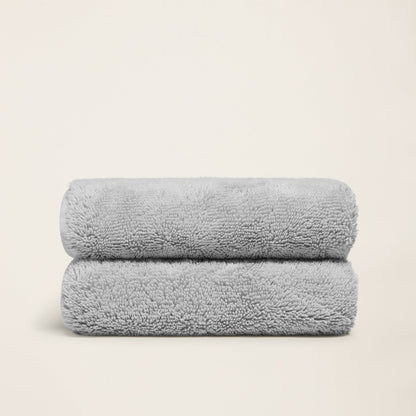 Light gray terry cotton towels, two folded towels with plush textured pile