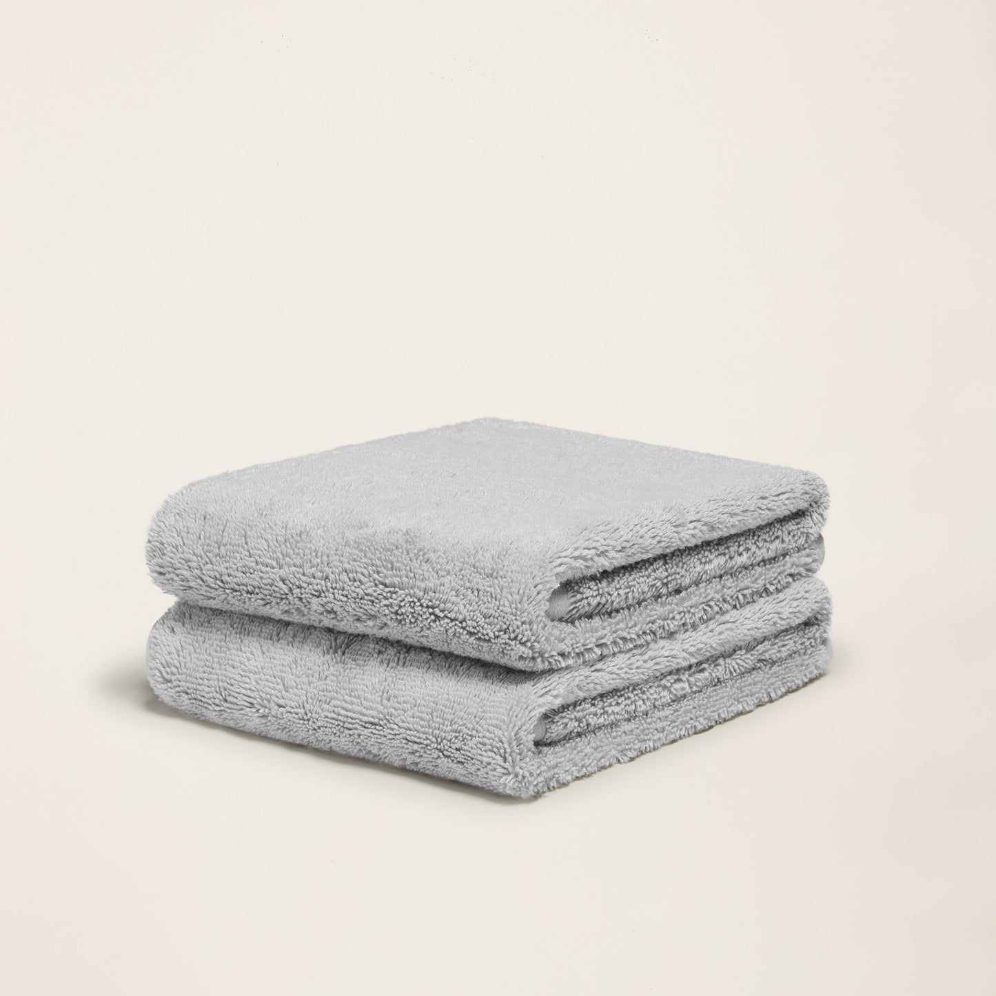 Light gray terry cotton towel set, two folded towels with dense plush surface