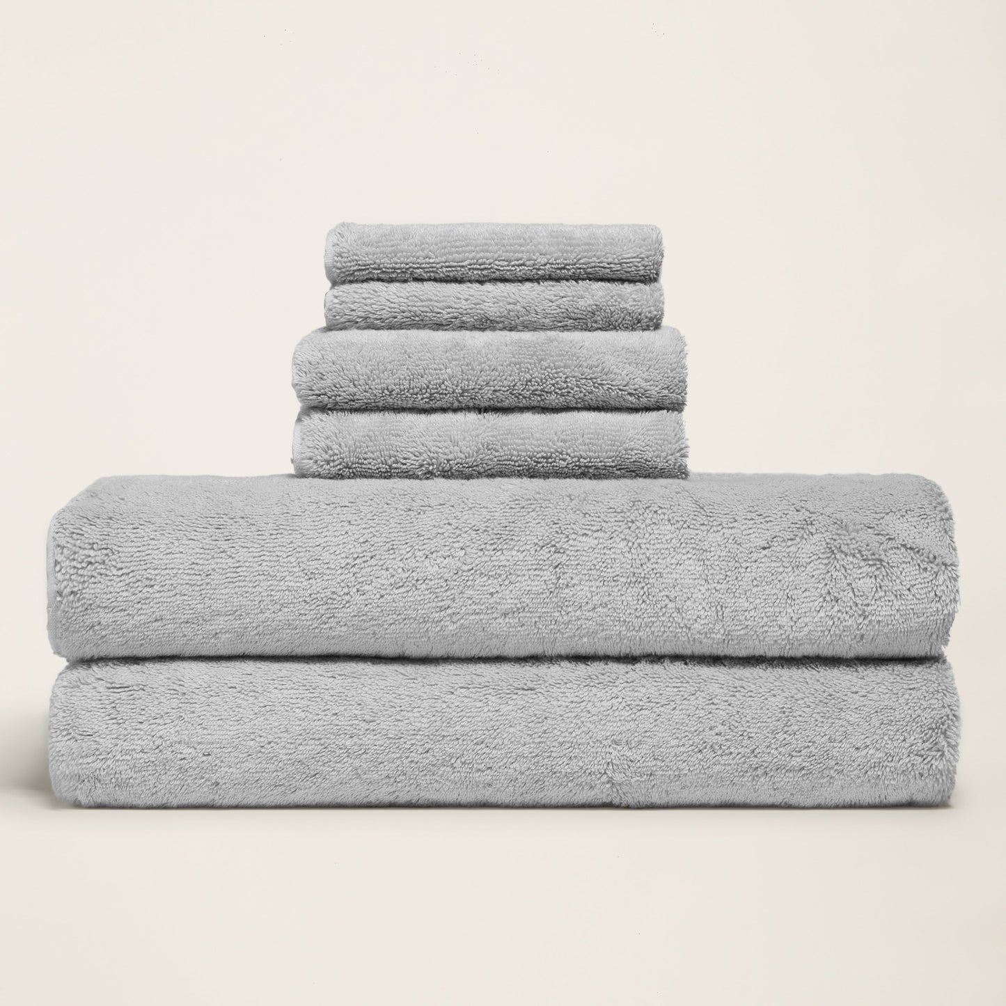 Light gray cotton towels folded in a stack, thick plush terry surface