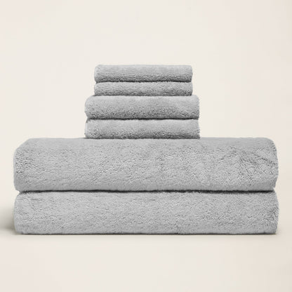 Light gray cotton towels folded in a stack, thick plush terry surface
