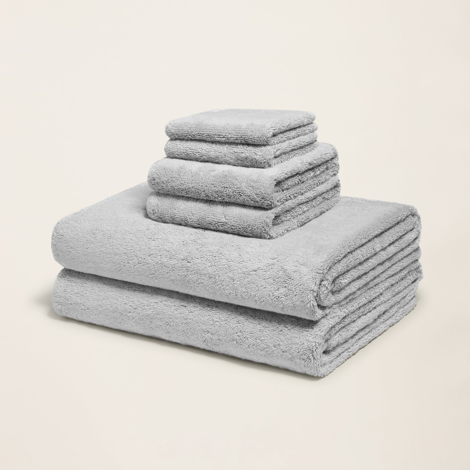 Light gray cotton towels folded in a stack, plush terry texture