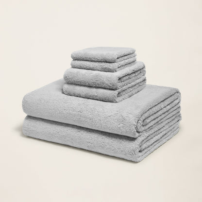 Light gray cotton towels folded in a stack, plush terry texture