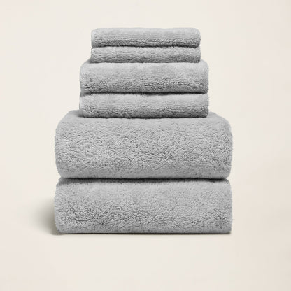 Light gray cotton towels folded in a stack, soft plush terry texture