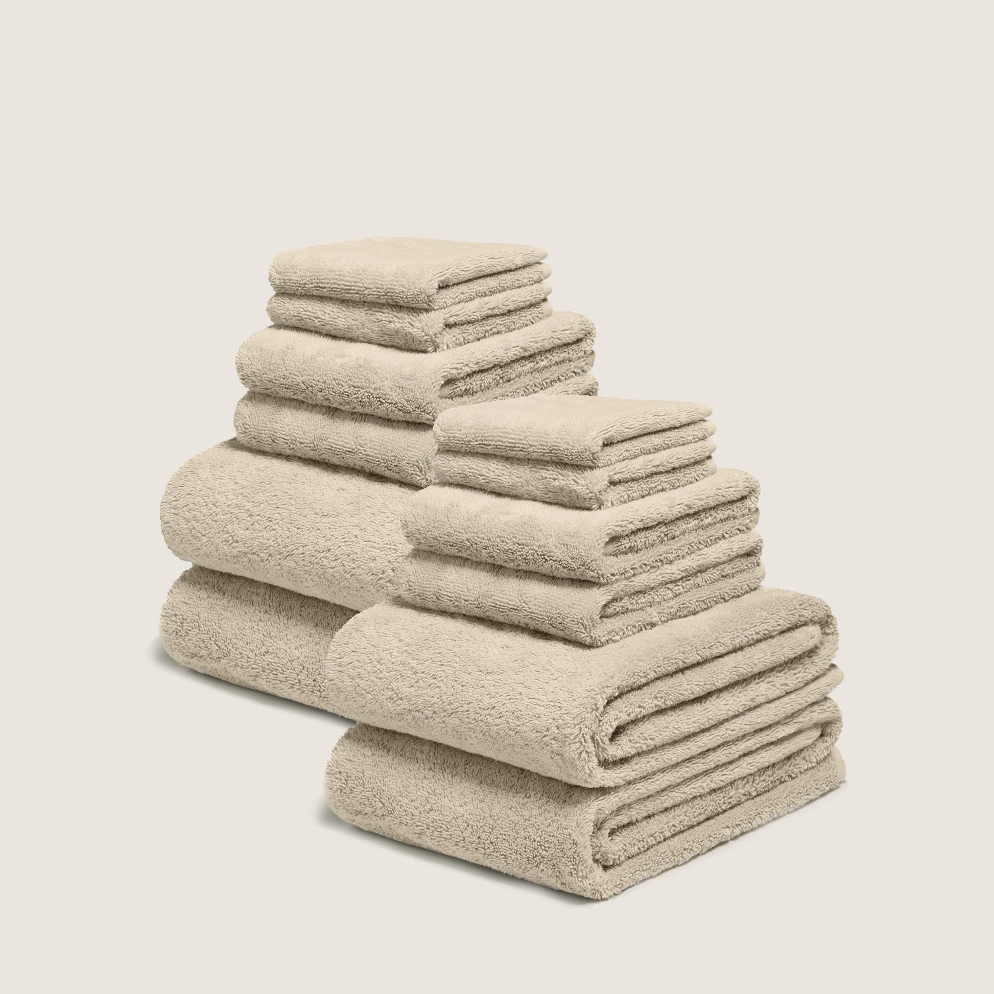 Cream cotton towel set with plush looped texture, stacked in multiple folds